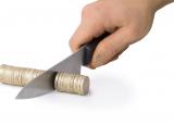 Row of pound coins, with knife slicing off a section