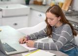 Teenage girl works remotely, at kitchen table